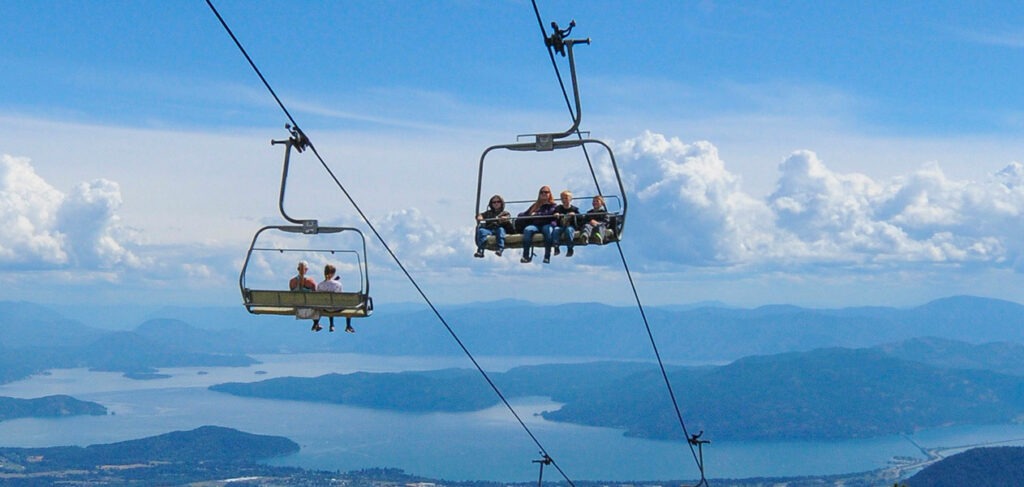 people riding Schweitzer mountain chairlifts in summer