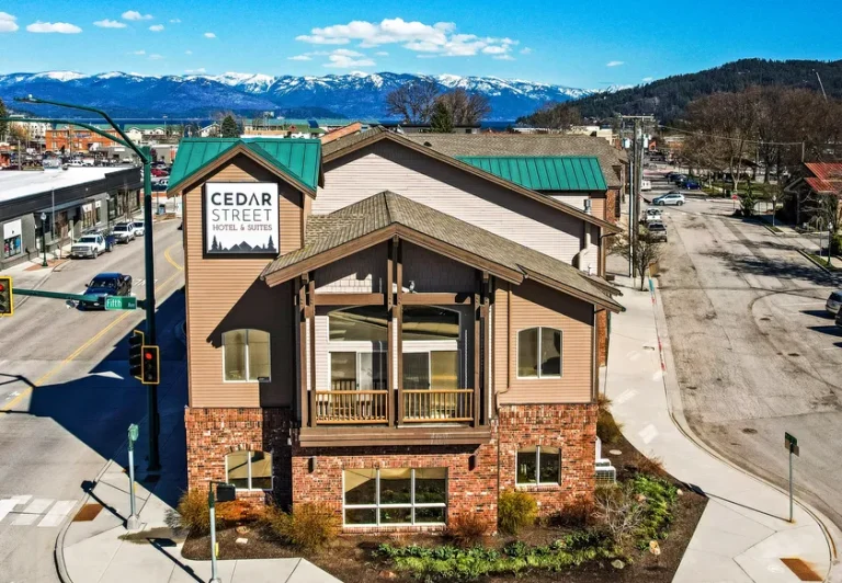 Cedar Street Hotel & Suites building view from above in Sandpoint, Idaho with snow capped mountains and Lake Pend Oreille in the distance
