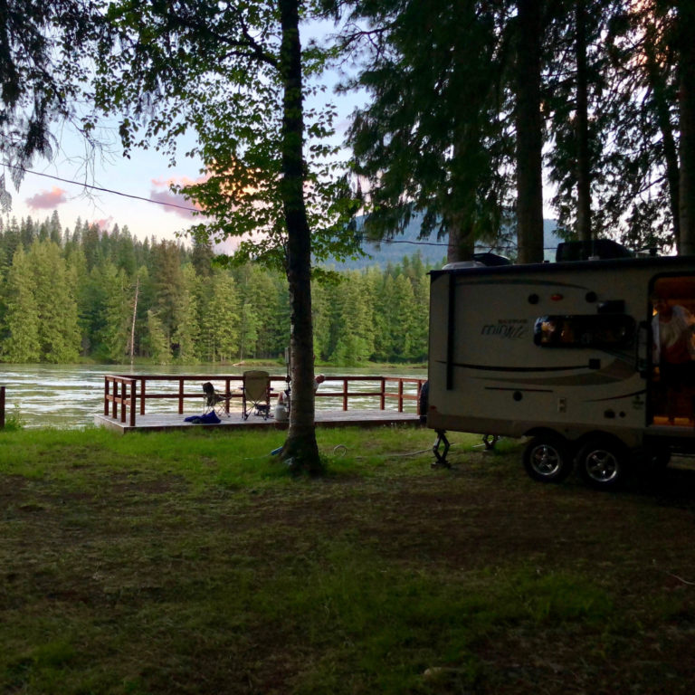 River Delta resort RV park campgrounds trailer on grass under shade of trees in Clark Fork