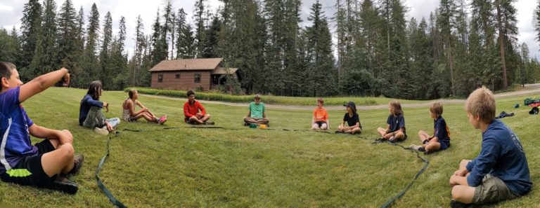 Youth group activity development experience kids in a circle on the grass SOLE Selkirk Outdoor Leadership & Education